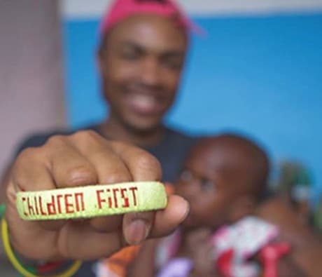 Antonio Edwards holding up a Children First wristband